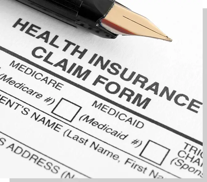 A health insurance claim form with a pen and pencil.